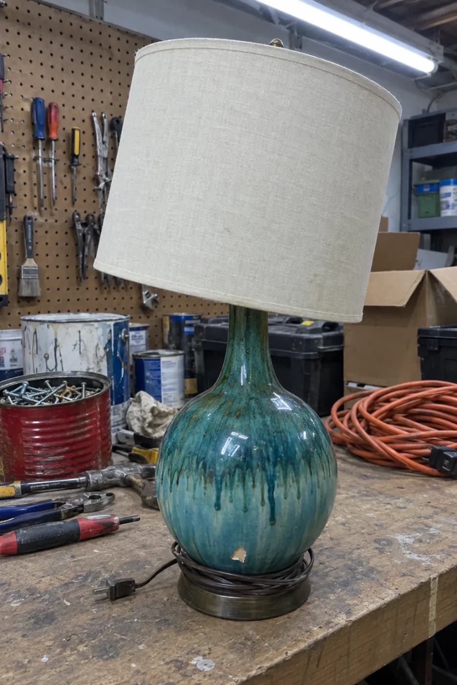 Sample phone photo of a teal ceramic table lamp on a cluttered garage workbench